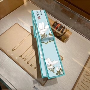 Dettaglio foulard in seta celeste con stampa di magnolia bianca e calligrafia elegante