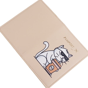 Close-up of pink PU leather passport holder featuring a cute cartoon cat and gold lettering