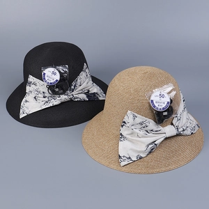 Detail of woven straw sun hats with UPF 50+ rating and elegant blue floral bow ribbons