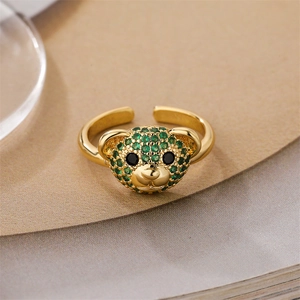 Macro shot of gold-plated open ring featuring a green micro-paved bear head detail