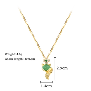Close-up of golden fox pendant with green zircon and pavé crystals on titanium chain