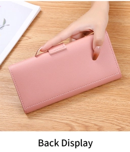 Handheld back view of a pink pebbled PU leather long wallet on a wooden desk background