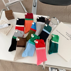 Flat lay of colorful cotton skateboarding socks on a white table with lifestyle props