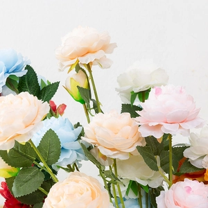 Close-up of artificial silk Ranunculus flowers with realistic texture and green leaves
