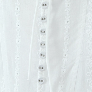White mini dress with floral embroidery and metallic buttons on a square neckline bodice