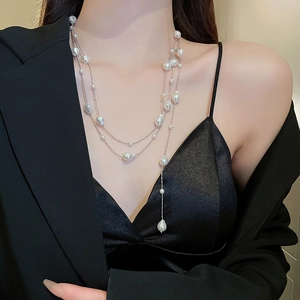 Elegant layered baroque pearl necklace on a model with stylish silver fringe details