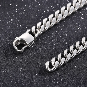 Classic silver Cuban link chain bracelet with lobster clasp on a dark textured background