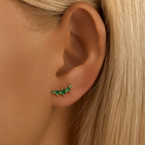Close-up of gold helix ear cuff with five green round zircon stones in curved row