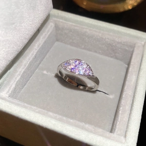 Close-up of sparkling zircon flower ring with twisted leaf design in a velvet jewelry box