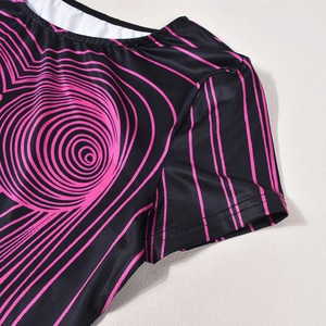 Détail du col rond et de l'épaule sur t-shirt noir avec motif de vagues roses