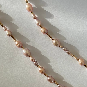 Detailed macro shot of pink baroque pearls and gold beads on an elegant necklace