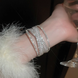 Close-up of a multi-layer silver bracelet with faux pearls and micro-pave crystals