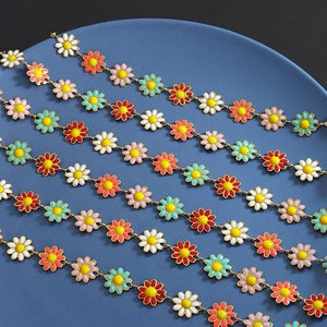 Colorful enamel daisy flower necklace and bracelet set on a blue ceramic display plate