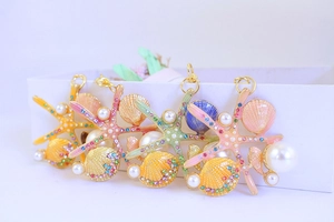 Detail of starfish and shell pendants with colorful enamel, rhinestones and pearls
