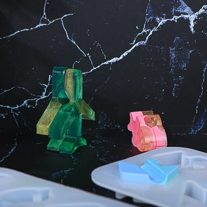 Detailed view of DIY resin molds with finished pink and green glittery figures