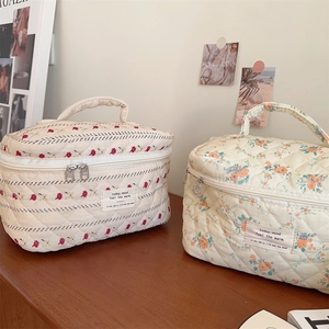 Vue détaillée des trousses à fleurs matelassées avec double fermeture et poignées