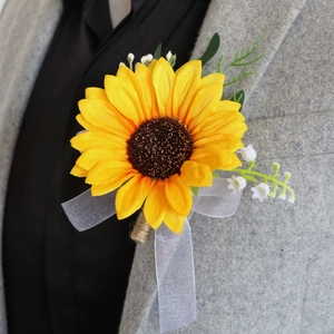 Sunflower boutonniere with white flowers and organza bow on a grey suit lapel