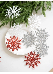 Dettaglio di fiocchi di neve glitterati rossi e bianchi su aghi di pino verde per Natale