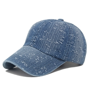 Detailed view of blue denim baseball cap featuring vertical stitching and washed texture