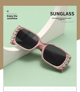 Detail view of pink rectangular sunglasses with sparkling rhinestone crystals on frame
