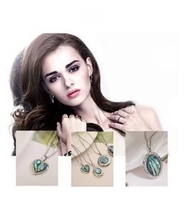 Detail of vintage carved heart and oval abalone shell locket pendants with fine chains