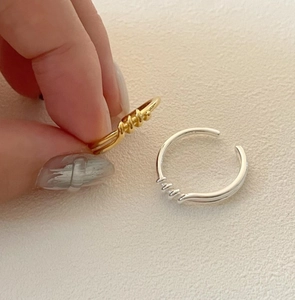 Detailed macro view of gold and silver twisted rope knot rings in adjustable open style