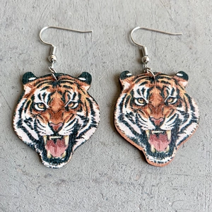 Detailed view of roar tiger head wooden drop earrings with silver metal hooks