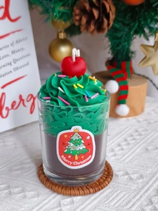 Detail of Christmas strawberry chocolate scented candle with green cream and cherry topping