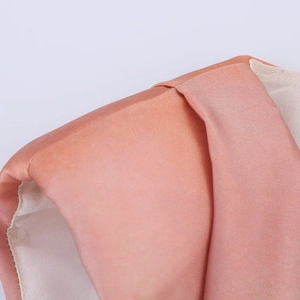 Détail du tissu en satin rose montrant des coutures fines et une doublure douce