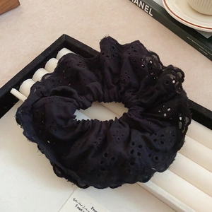 Close-up of black double-layered hollow lace scrunchie with intricate floral embroidery details