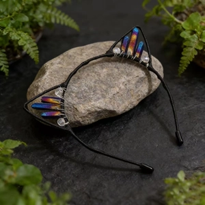 Macro shot of handmade cat ear headband with colorful crystals on a natural stone base