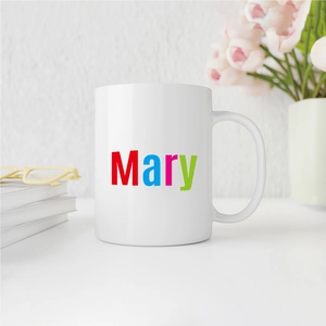 Customized white ceramic mug with colorful Mary name print and stylish floral desktop setup