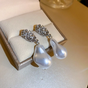 Detail of silver irregular metal texture and baroque pearls in a champagne jewelry box