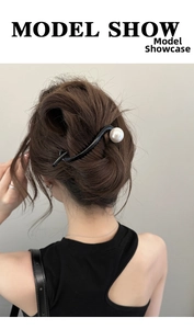 Pince à cheveux noire minimaliste avec perle blanche portée sur la coiffure du modèle