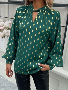 Detail showing the green lantern sleeves and gold polka dot pattern on the silky shirt