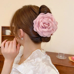 Close-up of pink layered fabric flower hair clip with realistic silk texture for women