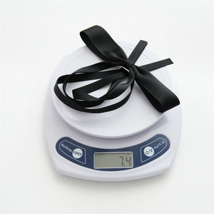 Detail shot showing a black satin bow hairclip on a digital scale weighing only 7.4g