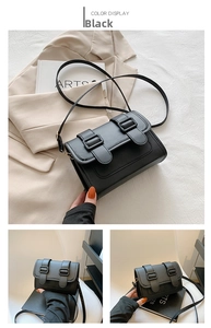 Detail shot of black PU leather crossbody bag featuring dual adjustable buckle straps