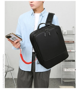 Detail showing side USB charging port on black business laptop backpack with external cable