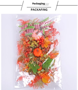 Detail view of autumn wreath with pumpkins and plaid bow inside clear packaging bag