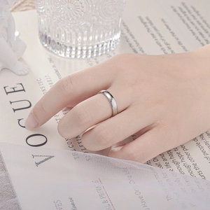 Close-up of polished silver minimalist band ring worn by model on a stylish background
