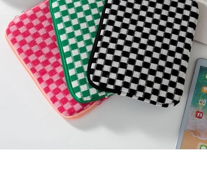 Close-up of thick knitted checkered laptop sleeve textures with secure zippers