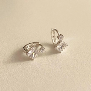 925 silver hoop earrings with square and round cubic zirconia stones on beige fabric