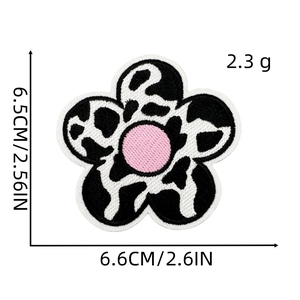 Flower shaped cow print embroidery patch with pink center and size measurements