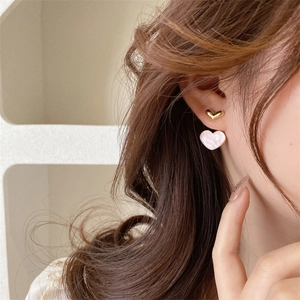 Pink heart-shaped double-layer earrings with gold accents on model's ear