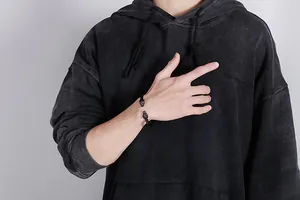 Detailed view of a black dual leopard head metal bracelet worn on a male wrist