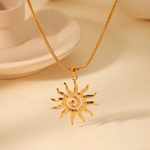 Detail of gold hammer-textured sun pendant with spiral center on a sleek snake chain