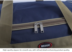 Close-up of a large blue travel bag featuring a sturdy dual zipper and green handles