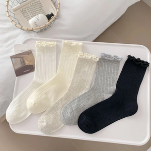 Close-up of five pairs of cotton ribbed mid-calf socks with elegant ruffled edges