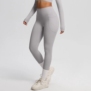 Detail view of high waisted light grey yoga pants showing functional side pocket and seams
